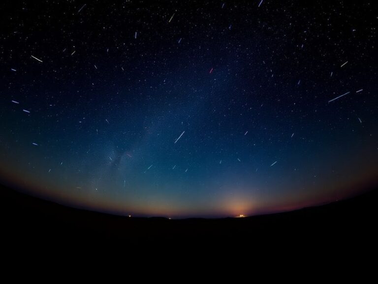 A wide-angle night sky photograph featuring multiple Lyrids meteors streaking across a star-filled sky, with the Milky Way vi