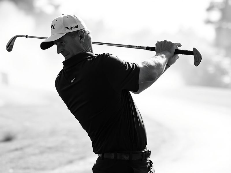 A high-resolution action shot of Jim Furyk mid-swing on a PGA Tour course, showcasing his signature looping motion, with a fo