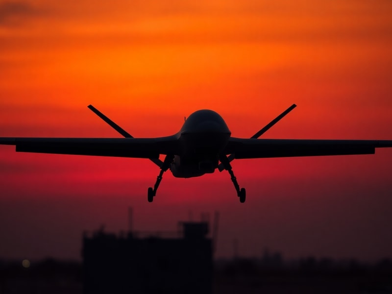 A split-image showing a military drone in flight over a war-torn landscape on one side, and a commercial drone flying over a