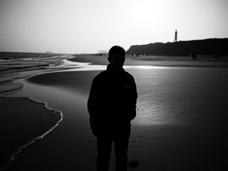 A veteran in military uniform standing solemnly at the American Cemetery in Normandy, overlooking the beaches, with a French