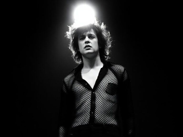 A moody, atmospheric portrait of Robert Smith in a dimly lit room, wearing his signature smudged lipstick and dark eyeliner,