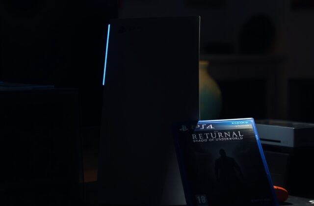 A futuristic gaming setup on a wooden desk with a PlayStation 5 console, DualSense controller, and a large monitor displaying