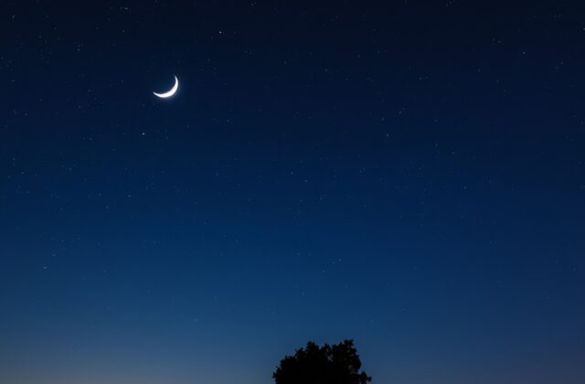 A breathtaking image of the crescent moon and Jupiter in a clear night sky, showcasing their proximity and brilliance against